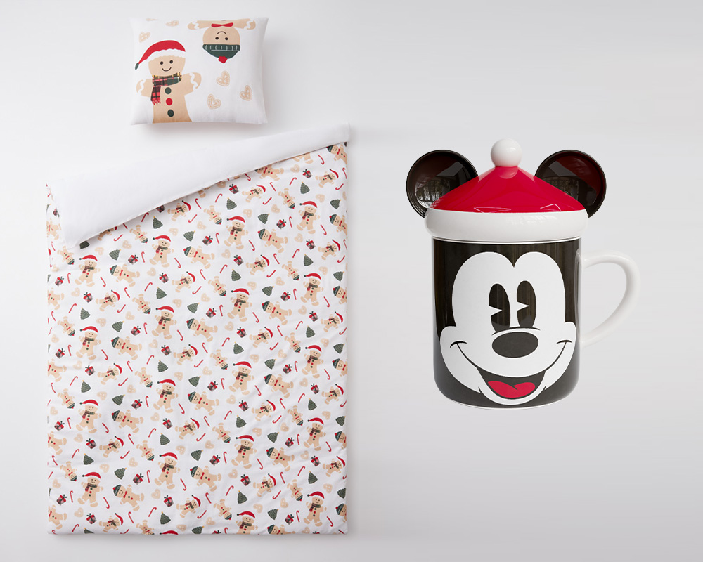 Vánoční povlečení od společnosti Pepco na dětský dárek vedle vánočního dárkového hrnečku s motivem Mickey Mouse.
