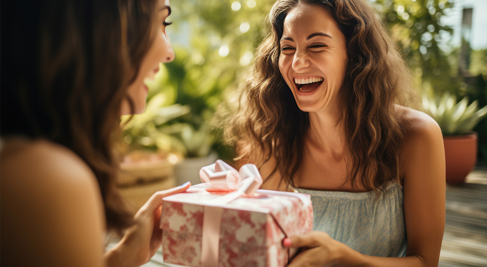 Usměvavá žena předává dárek příteli.