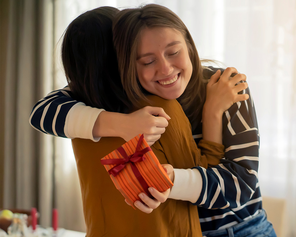 Dívka dává dárek své sestře a také kamarádce.
