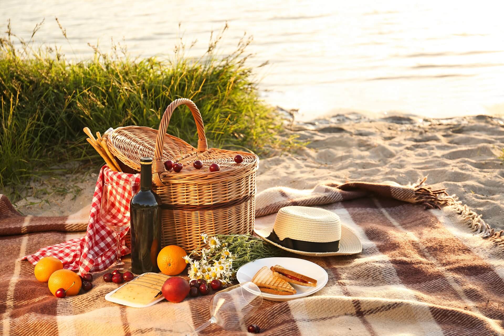 Piknikový koš na romantickou večeři na pláži u řeky.