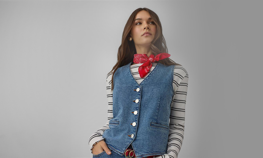 Žena v modré džínové vestě a červené šátku na krku.